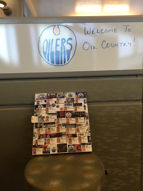 White board says "Welcome to Oil Country!" with Oilers logo, Advent calendar leaning against wall below white board.