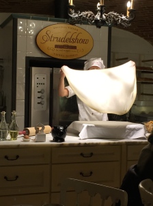 Baker in process of throwing up dough to stretch it to make strudel